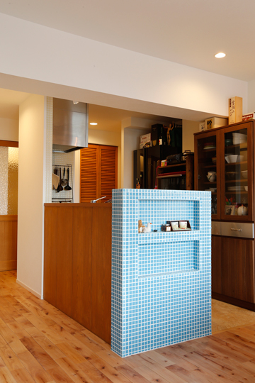 キッチンのリビング側の壁面にはさわやかなブルータイル。小物が飾れるニッチを設けています