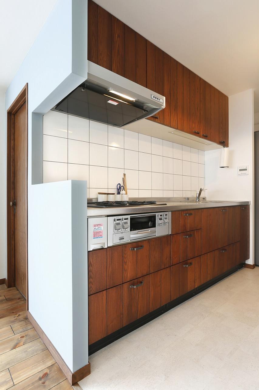 キッチンは既存のものを再利用。収納の扉をタモ材で造作してイメージを一新しました