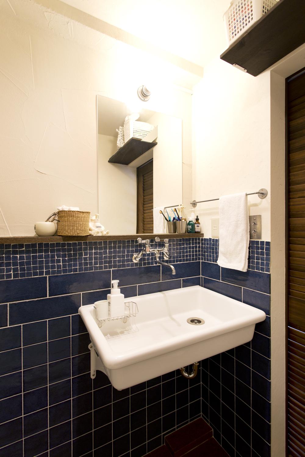 洗面台はシンクのみのシンプルなデザイン。壁は正方形、長方形、モザイクと同じ紺色ながら三種類のタイルを組み合わせました