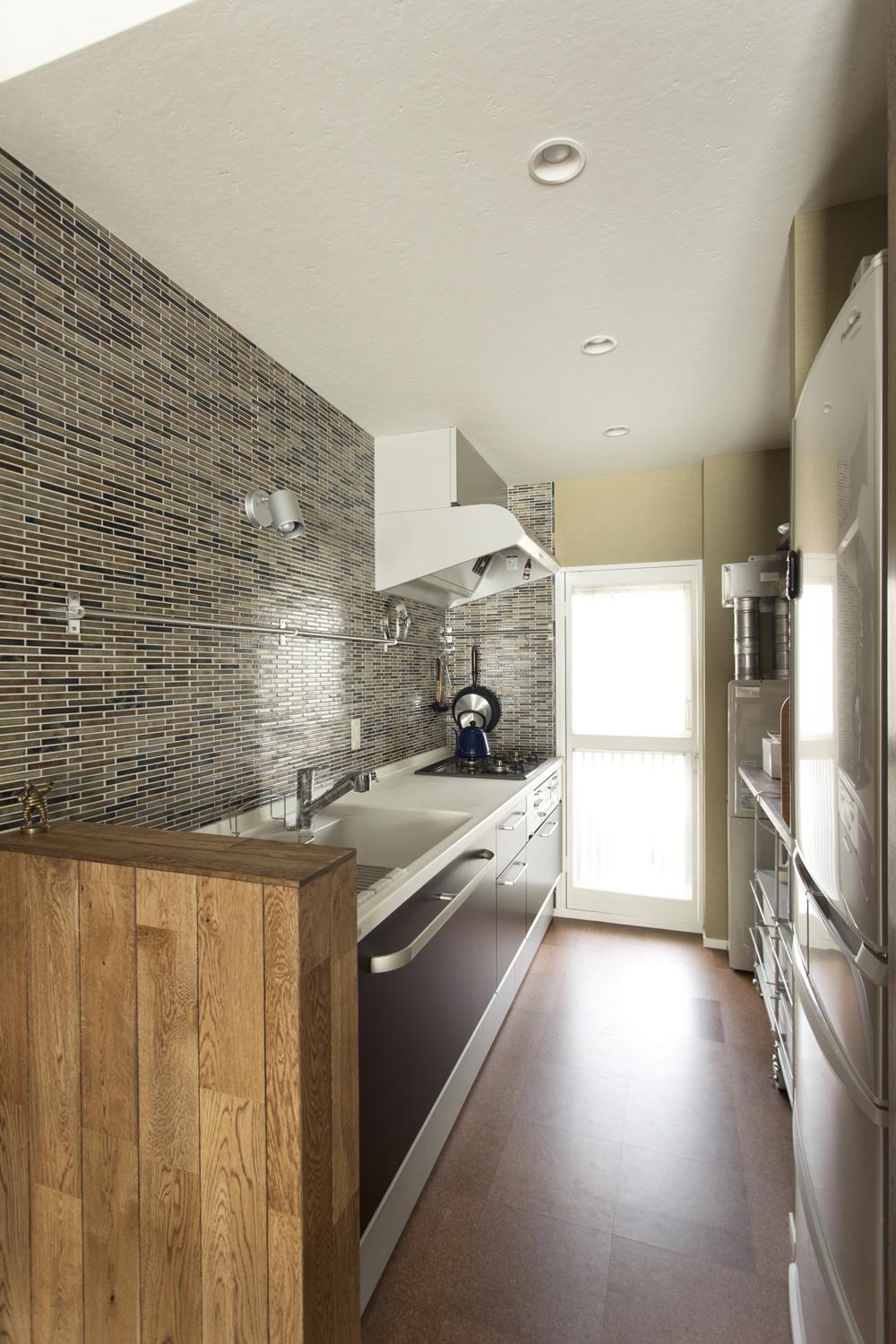 キッチンの、リビングから見える部分の壁にはタイルを貼り、雰囲気を一新