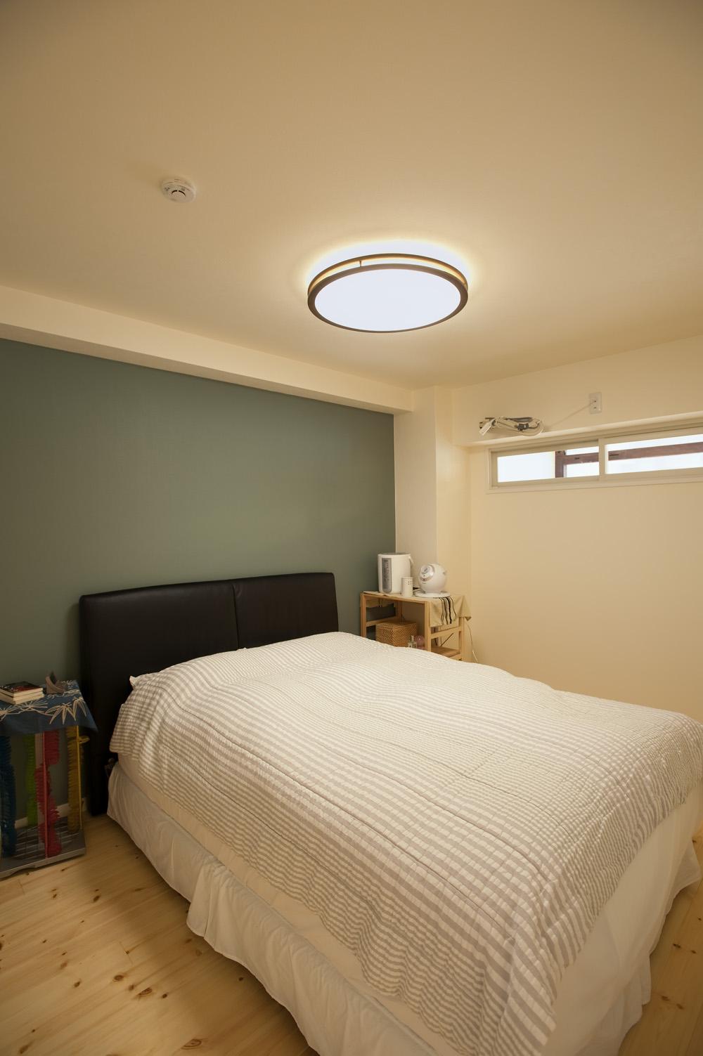 寝室の壁は一面のみブルーグレイのアクセントクロスを入れました。リビングとを仕切る壁の上部に窓をつくって、ベランダからの風を取り込めるようにしています。