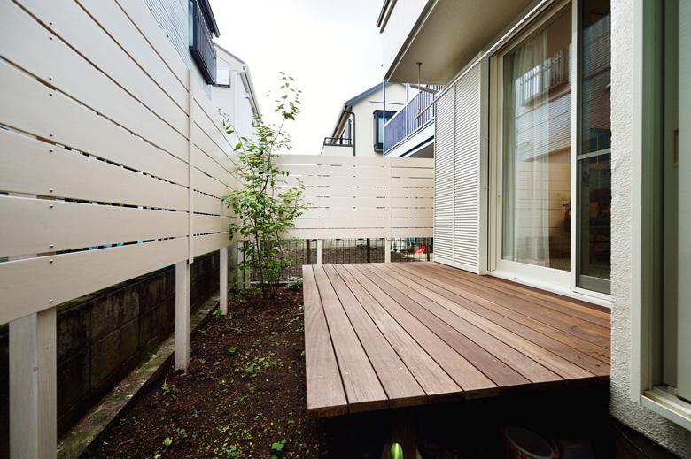 リビングの外には、子どもたちが外で遊べるウッドデッキを造作。対面キッチンからも見渡せて、安心。隣家が近いため、境界には白いウッドフェンスを設置し、プライバシーにも配慮しました。