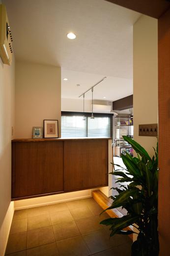 リビングと壁で仕切られていた玄関ホールは、開放感を優先してリビングとつながるオープンな空間に。下足収納は腰までの高さにして、玄関からリビングが見渡せるように