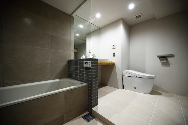 浴室、洗面室、トイレと分かれていた水まわりを一体化。ホテルのような開放的な空間が生まれました。限られた空間をより広々と感じられるよう、浴室と洗面室の間はガラスで仕切って視線が抜けるようにしました。シンプルな洗面カウンターは造作