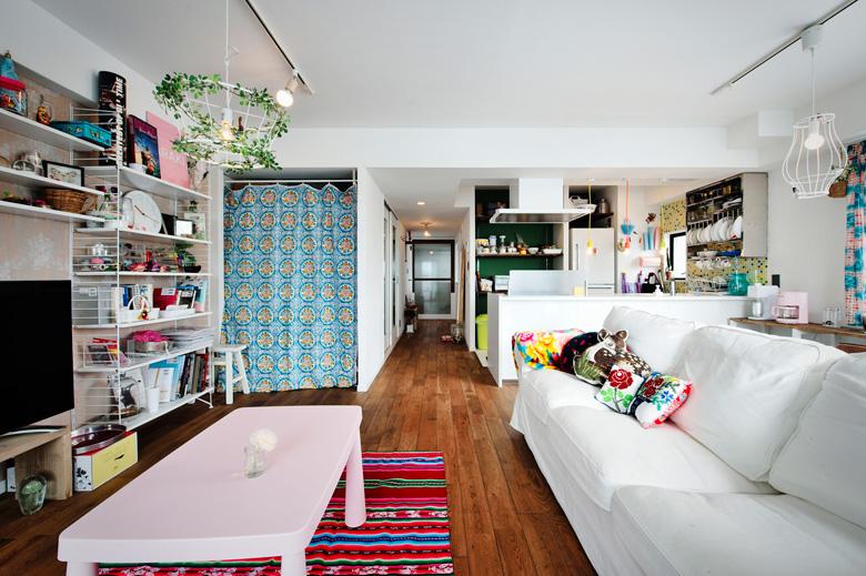 リビングと和室の間仕切りをなくした広々としたＬＤＫ。廊下の部分は幅を広げてリビングに取り込みました。元和室の押入れは内部を作り変えて収納スペースに。扉はあえて付けずにUさん手作りのカーテンで目隠しにしました。テレビのある壁のみ、Uさんが選んだ輸入クロスを。