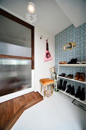 玄関は下足収納をなくし、さらに廊下と同じように横幅を広げてより広く使えるように。廊下とはガラスの入った建具で仕切っている。壁は一面のみUさんが選んだ輸入クロスを取り入れた