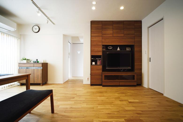 住まいの中央に位置するリビングは、間取りはそのままに。北面の光が届かない部分は一部納戸にして、家族みんなの収納スペースとした。テレビまわりは、テレビの大きさに合わせた壁面収納を。床はナラ無垢材を使用