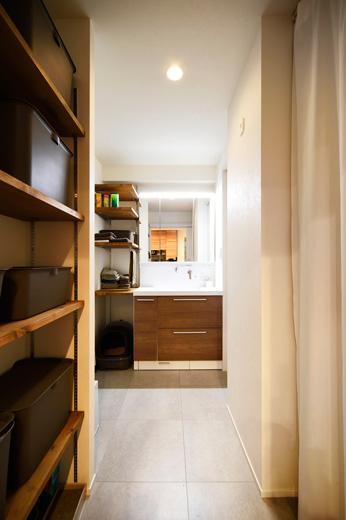 洗面室は廊下だった部分を取り込み、洗濯機をおけるスペースをつくった。洗面カウンターなど設備も一新。着替えやタオルなど洗面・脱衣室で使うものをその場で片付けられる収納棚を造作し、使いやすく