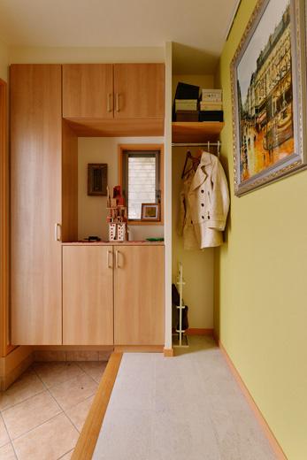 玄関ホール、たたきともに必要以上に広かった玄関は、どちらも4人家族に必要な空間を残し、他のスペースは音楽室に変更。たたきのタイルは既存のまま。ホールの床は白のコルクタイル。壁は明るいグリーンのアクセントクロスを採用。下足収納は新しく木製の製品を入れ、残ったスペースにはオープンクロゼットを造作した