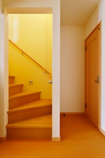 玄関から直接2階に上がっていた階段を架け替えて、リビング階段に。2階の個室に上がる前に必ずリビングを通るような動線となった。階段の壁は薄いオレンジのクロスで明るく温かな雰囲気に