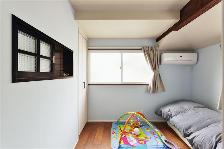 2階のキッチンの隣に将来の子ども部屋を用意。床はオーク三層無垢材。壁は一面のみブルーのアクセントクロスを。キッチンと仕切る壁には内窓を設け、料理をしながらもお子さんと会話ができるように