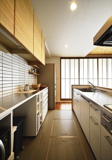 壁付けだったキッチンはリビングに向け、オープンな対面キッチンに。吊り収納は既存の収納に、扉のみタモ材で造作し、統一感を持たせた。