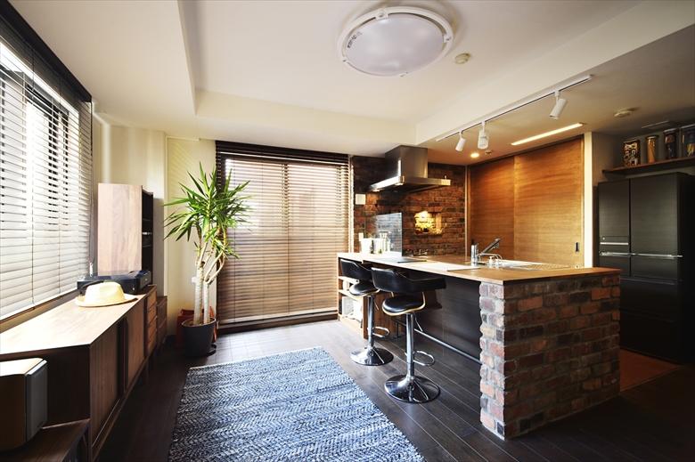 バーカウンターのあるスタイリッシュなＬＤＫ。壁付けだったキッチンはオープンなペニンシュラキッチンに。床はマンションの規定により防音フローリング。表面はレトロブラウンの無垢材の突板。壁は珪藻土仕上げ
