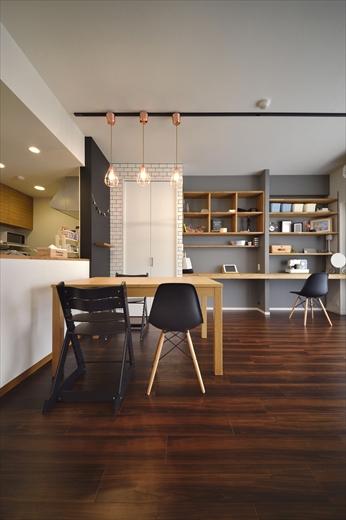 素材の質感を楽しめるアンティークな雰囲気に変えたいというご希望。床の濃茶を活かし、壁はアクセントクロスや黒板塗装、磁器タイルなど多様な素材を取り入れ、質感の変化を演出。収納の扉は無垢材で造作し、木の温かみを感じられる空間に。