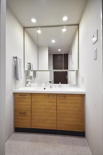 洗面カウンターも既存のまま。扉のみ、柾目のタモ材で造作。モダンなデザインが温もりのある雰囲気に一新