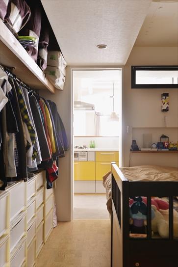 朝、起きたらすぐにキッチンに出られるよう、寝室はキッチンの隣に。キッチンとの壁には上部に窓を設け、朝の光が入るようにした。反対側は洗面室。寝室のウォークインクロゼットは、寝室側とリビング側の２列になっていて、両側から出し入れできる。