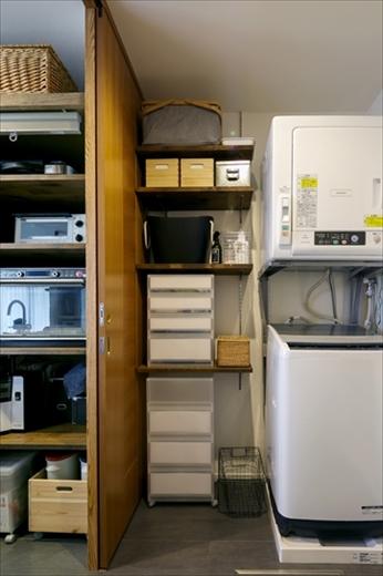 デッドスペースを生かした収納棚を造作し、空間を有効活用。洗面カウンターと洗濯機置き場の場所を逆にすることで、キッチンの並びに洗濯機を置けるようにした。