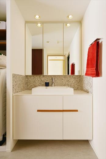 使いやすさとデザイン性を考えた洗面台は造作。両開きに見える扉の右側が実は引き出しになっている。立ち上がりにはタイルを貼ってアクセントに