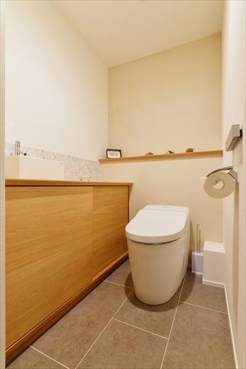 トイレは設備を変えて新しく。カウンターはナラ材で造作。開き扉で開けにくかった建具は引違い戸にしてより使いやすくした。壁は一面のみ薄く色のついた珪藻土で仕上げ、温かみのある空間に