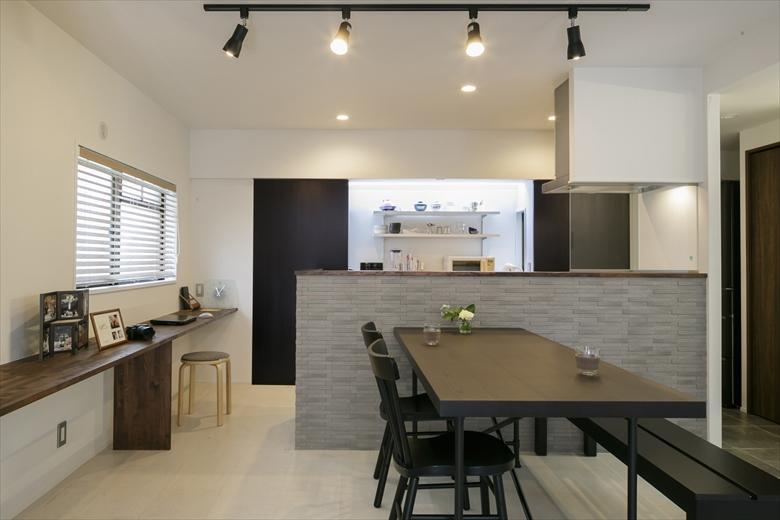 キッチンは対面のカウンターキッチン。タイル貼りのカウンターは造作。キッチン横からダイニングにかけて、パソコンや作業ができるカウンターデスクを設けた。キッチンのカウンター奥のパントリーや洗面室はダイニングにつながり、ぐるりと回遊できる動線となっている