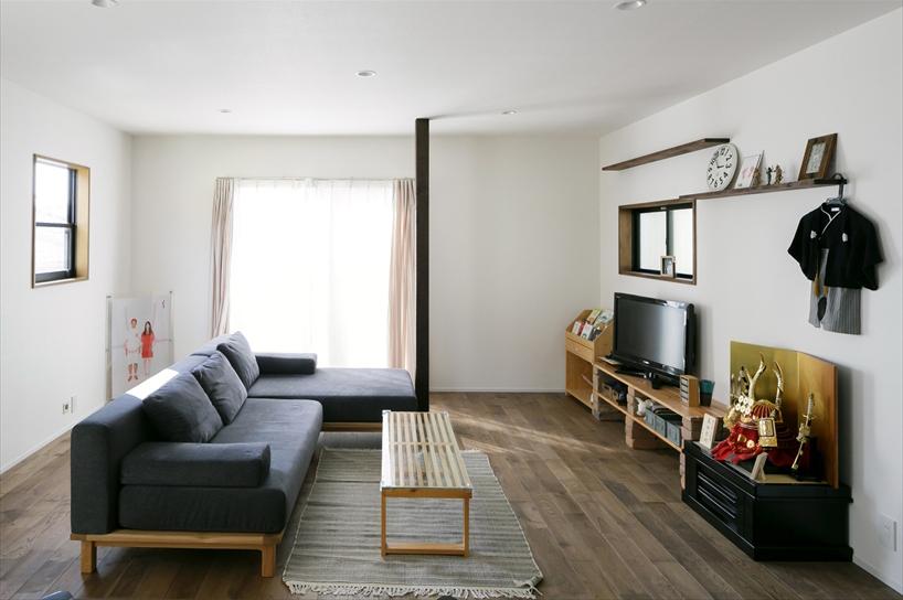 正面の掃き出し窓の隣にあったキッチンを移動し、開放的なリビングに。柱はもともとキッチンの壁があった部分をそのまま残した。床はナラ無垢材を落ち着いた色合いのオイル塗装。テレビを置いた壁は、アクセントクロスにするか悩んだそうだが、何度も話し合いを重ね、飾り棚でスッキリさせるデザインに