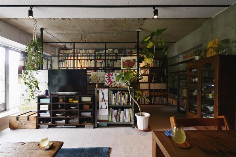 リビングと洋室を一体化して広々としたＬＤＫ。壁は躯体を現しにすることでコンクリートの質感を楽しめる。スチールとガラスの仕切りの奥はワークスペース。Oさんがもともとお持ちの家具が違和感なく馴染むようにプランニングした