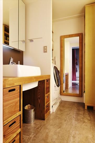 洗面室は場所はそのままに、カウンターを造作。カウンターの引き出しはニトリの製品。引き出しの大きさに合わせて、カウンターのデザインを設計した。洗濯機の向かいにある収納棚は無印良品のもの