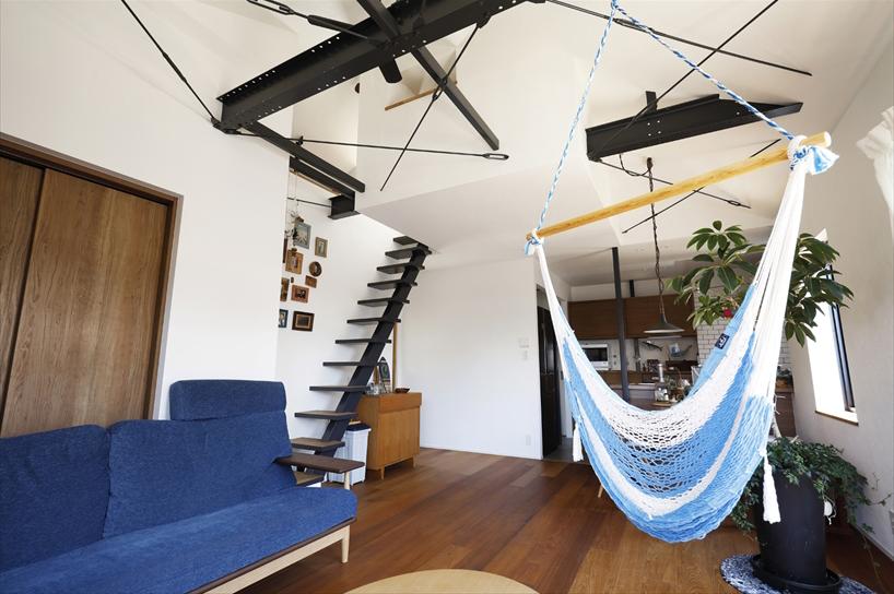 2階子世帯のリビングは、天井をあけて勾配天井に。出てきた梁やブレスはそのまま見せ、さらにTさん憧れのハンモックを取り付けるなど有効活用。小屋裏に隠れていたロフトもリビングと繋がる窓を設け、見せるロフトとして部屋の一部に取り入れた。ハシゴで上がっていたが、階段とすることでより便利に。