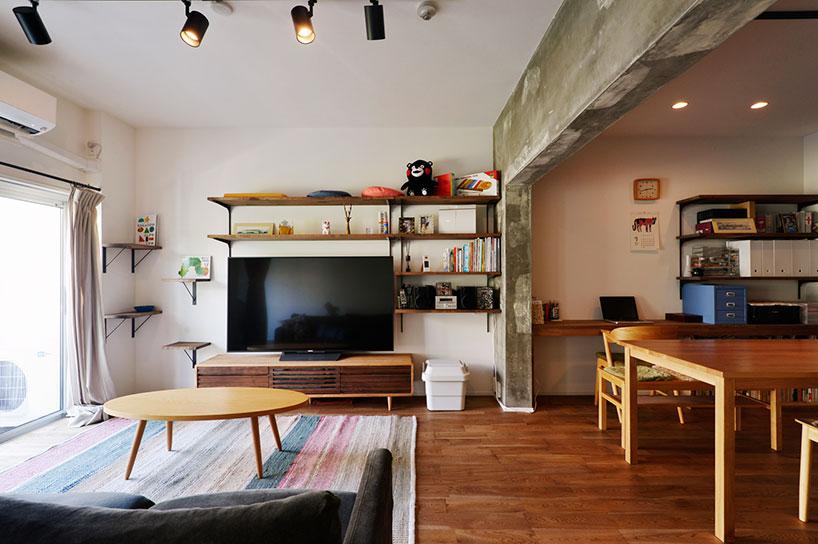 和室と一体化して広々とした空間を実現したリビング。隣のダイニングとはコンクリートの現しにした梁が緩やかに空間を分けている。床はナラ材のオイル塗装。直床だったため、無垢材を敷くために置床で対応した。バルコニー側には愛猫が外を眺められるようにキャットウォークを造作