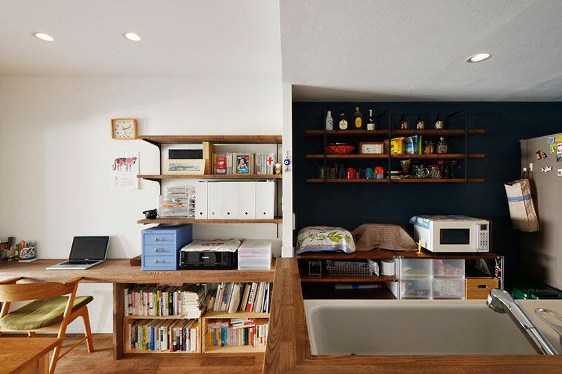 右側がキッチン、左側がダイニング。キッチンの収納は、カウンターはもともとお持ちのテレビ台を再利用。カウンター上の棚は、デザインを合わせて造作した。ダイニング側には壁面にカウンターデスクと棚を造作。デスクは夫人がパソコンしたり家事作業をしたりと多目的に使うことができるスペース