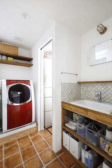 キッチンから出入りできる洗面室の動線が気に入っているということから、間取りはそのままに。洗面カウンターはタモ材で造作。オープンなデザインで使いやすい。洗濯機の上にも棚を設け、こまごましたものもすっきり収納できる。床はフロアタイル