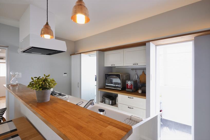 キッチンの奥は、もともと和室の広縁があった所を、半分をパントリー、残りの半分を室内干しスペースに。それぞれ、カップボードを挟んで左右の入口から出入りできる。パントリーの内部には作業用カウンターを造作。家事スペースとして活躍している