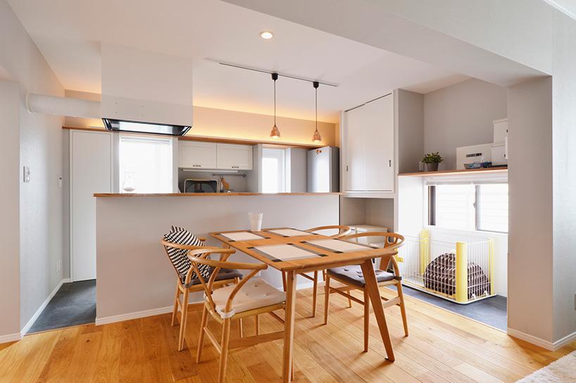 料理をしながらリビングやダイニングの家族と会話ができる対面キッチン。すっきりとしたデザインのカウンターは造作。ダイニングの窓側は、一部だけキッチンと同じフロアタイルを貼り、愛犬のケージ置き場に。汚れてもすぐにお手入れできる