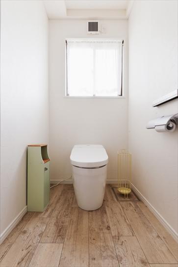 トイレは場所はそのままに、設備を新しく。床は木目調のフロアタイルで温もりのある雰囲気を演出。壁は白のクロスで明るく清潔感のある空間を実現
