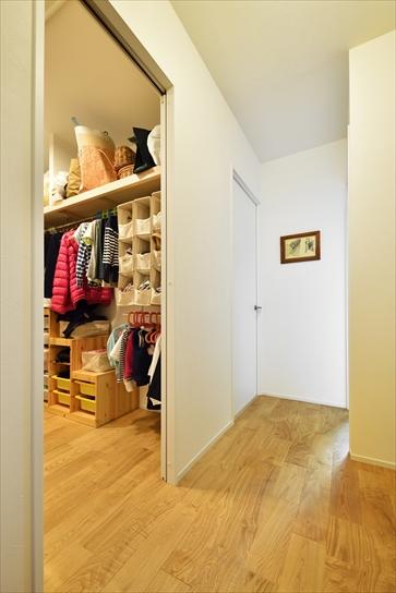 廊下側と居室側の2面に分かれていた収納をひとつにし、さらに居室を縮小した分を取り込んで拡大。たっぷりとした広さのファミリークロゼットが出来上がった。スッキリと使いやすそうな収納術も見事