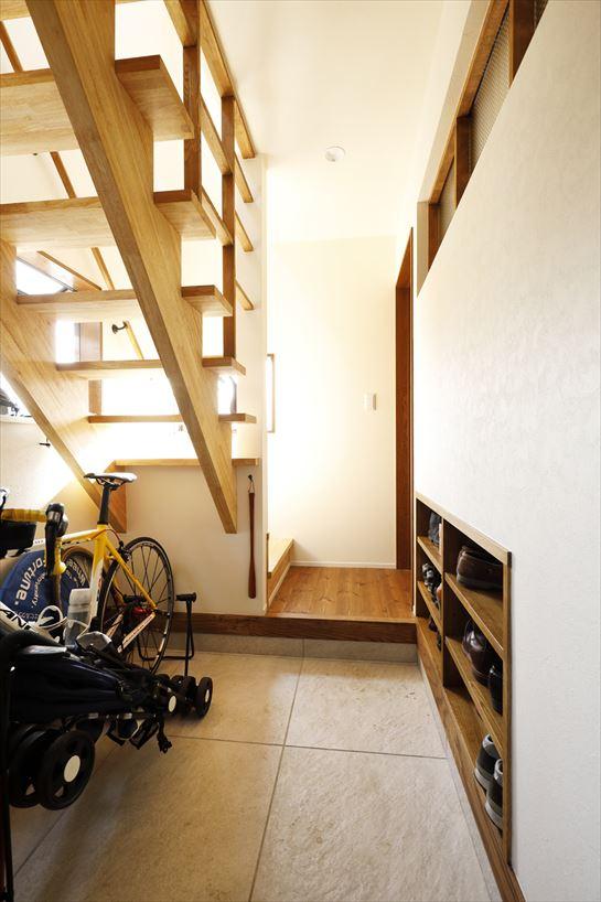 玄関ドアは一つだが、中で親世帯と子世帯への入り口が分かれいているというユニークな発想。架け替えた階段は光を通すスケルトンタイプに。空間をうまく活用した収納にも工夫が光る