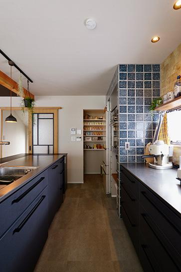 キッチンには奥さまのこだわりが満載。前後の引き出しを開けてもぶつからない広さをセンチ単位で指定したという。設備にもこだわられ、外国製の食洗機やオーブンが組み込まれている。正面のパントリーはリビングから丸見えにならないよう新たに壁を設け、内側には可動棚を。2種類のテイストが異なるタイルを使ったデザイン