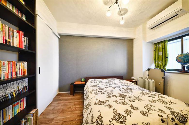 主寝室はグレーのアクセントクロスで落ち着いた雰囲気に。既存のクロゼットと隣り合った和室の押入れを合体し、和室の一部も取り込んで広々としたウォークインクロゼットを設けた。主寝室・子ども部屋・廊下の3方向から出入りでき、使い勝手も容量も申し分なし