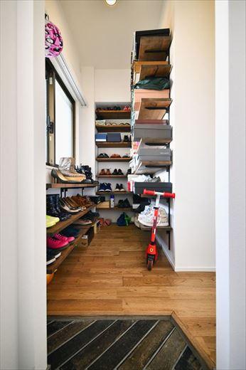 玄関を入って左手の居室空間を利用して、オープンなシューズインクロゼットともうひとつのウォークインクロゼットを設置。土間にはせずに床を敷いたことで室内からも使いやすく、靴の脱ぎ履きもスムーズに。ヘリンボーン貼りにした土間タイルが高級感を漂わせる