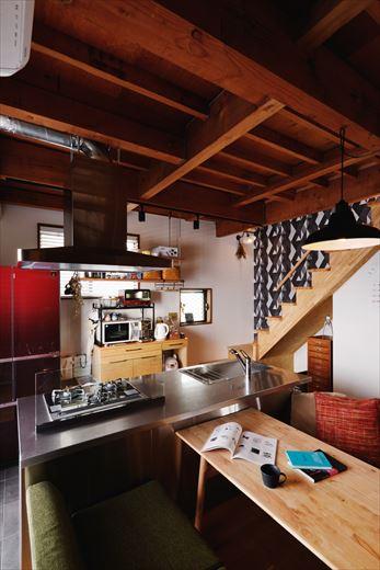 アイランドに配したオールステンレスのキッチンは奥様のこだわり。リビング・ダイニングが見渡せるのでお子様が小さいうちも安心。「吊り棚の棚板もしっかり造っていただいて、重いものも載せられます」と使い勝手の良さにも喜ばれている。階段下のデッドスペースも活かして手持ちの家具が入るように工夫している