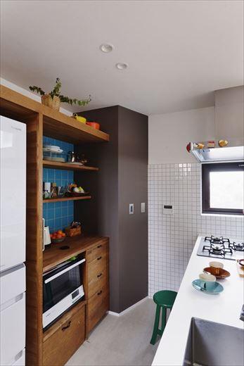 奥様が特にこだわったのがキッチン周り。家具職人による造作の収納や棚はしまうと飾るを両立したもの。色味やタイル使いにもこだわってイメージをカタチにされた。キッチンの向きを変えたことで水回りへの動線もよくなり、新たにパントリーも設置。よりいっそう家事が楽しくラクになった