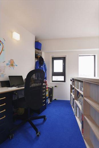 吹き抜けに面した書斎スペースは吹き抜けを少し狭めることで広さを確保。再構築した窓の位置と吹き抜けに面した腰壁にスリットを設置したことで階下にもたらす開放感と明るさはより高まった。効率アップに効果があると言われるブルーをアクセントカラーに