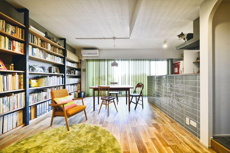 床はナラの無垢フローリングを採用。Kさん夫妻は当初、無垢＋モノトーンで統一しようと思っていたが、その後、打ち合わせを重ねていくうちに、色味をプラスする方向へ。リビングのラグやバーチカルブラインドに好きなグリーンを取り入れた。オープンな対面キッチンの腰壁には大きめのタイル貼りを施し、お洒落な雰囲気に