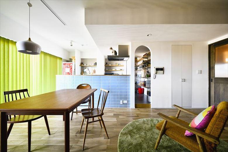 閉鎖的で窮屈な印象だったキッチンが大変身。まず、大容量が確保できる位置にパントリーを置き、そこからキッチンの位置を導き出した。ベランダに面した窓からの光が届き、昼間は手元を明るく照らしてくれる。パントリーはリビング側のアール開口にもキッチン側の開口にも扉はつけず、行き来がしやすい。