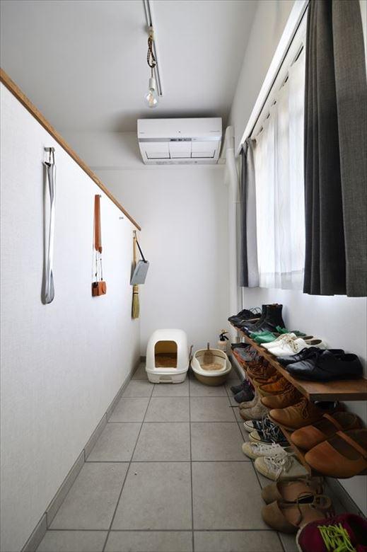 玄関を入って右手の居室の壁を撤去。土間スペースを広げてシュークロークと愛猫のトイレスペースを確保した。新たに設けた仕事用スペースとの仕切り壁は、上を開けて開放感とつながりを演出。光と風も採り込める