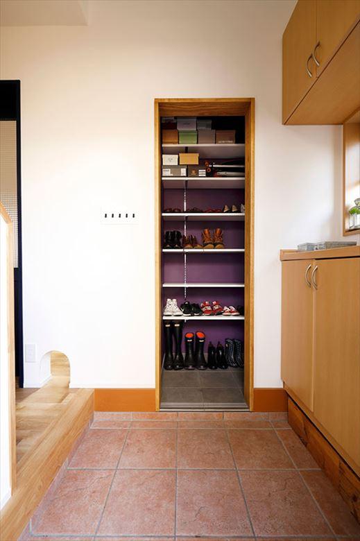 和室の一部を取り込んで実現したシューズインクロゼット。玄関を開けると正面に位置するため、印象的な紫のクロスを使ってかっこいい雰囲気に。これまで土間や靴箱の上に並んでいた家族の靴がすっきりと収まっている