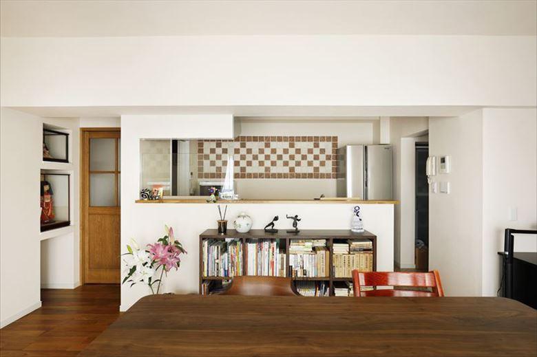 キッチンは開口を広げ、背面にあった吊り戸棚を撤去。オープンで広々とした印象となった。料理をしながら窓越しの景色を楽しむことができる。リビングからもよく見える背面にはアンティーク加工を施した大理石をデザイン的に配して空間のアクセントに。デザインパターンはいくつかの提案の中から選んだもの