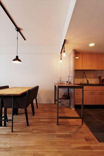 ご夫婦で料理を楽しまれることもあるというキッチンは壁を取り払ってオープンな空間に。当初は作業台の設置も要望のひとつだったが、後々簡単に取り外すこともできるテーブルを作業台代わりに設置した。キッチンの床は掃除のしやすいフロアタイルを採用