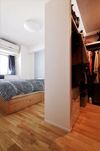 寝室のアクセントクロスはブルーを選んで爽やかな雰囲気に仕上げた。ウォークインクロゼットは拡大するとともに扉をなくしてオープンスタイルに。Ｌ字型だった収納スペースがコの字型になり使い勝手も容量も向上。間仕切り壁の上部を開けたことで風通しも良くなった