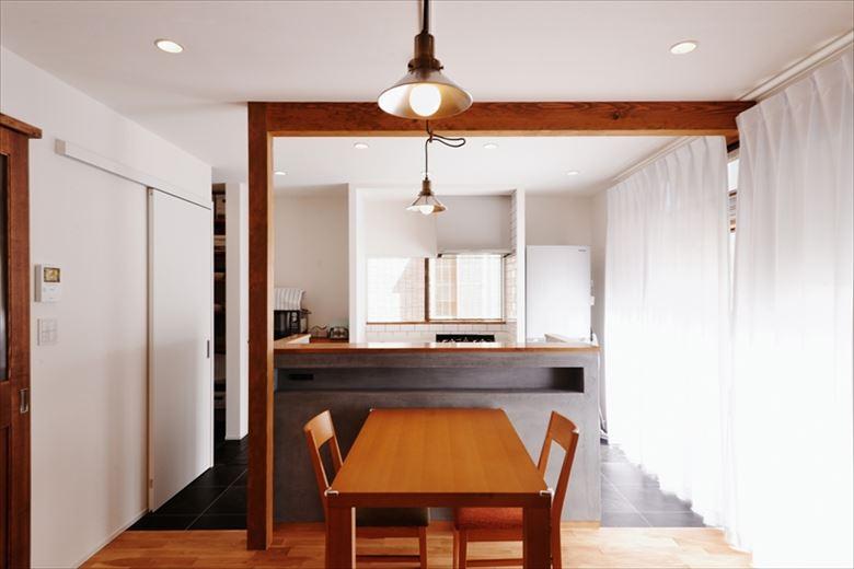 リビングに隣接していた和室を撤去してひと続きの空間とした上で、壁付きだったキッチンを反対側へ大移動。ダイニング・リビングが見渡せるアイランドのII型に変更した。また、ナラの無垢フローリングとキッチン立ち上がりのモルタル調の左官材「モールテックス」の異素材の組み合わせを楽しめるおしゃれな空間に